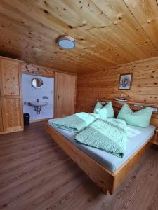 um quarto com uma cama num chalé de madeira em Ferienwohnung Juen em Sankt Gallenkirch