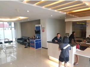 een jong kind dat aan een balie in een kantoor staat bij 2 BR Sea View 2 Big Bed 1 Sofa bed Internet Kitchen in Jakarta