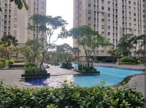 een zwembad in een stad met hoge gebouwen bij 2 BR Sea View 2 Big Bed 1 Sofa bed Internet Kitchen in Jakarta