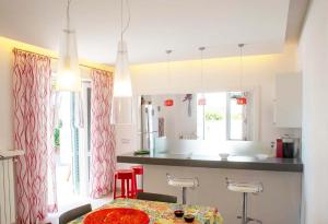 eine Küche mit einem Tisch und einem Esszimmer in der Unterkunft Villa White Dahlia in Torre Suda