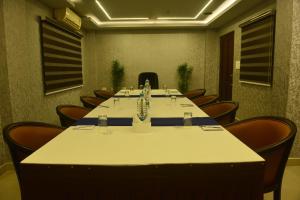 una sala de conferencias con una mesa larga y sillas en Hotel Seven Hills en Thiruvananthapuram