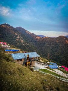 une maison sur une colline avec des panneaux solaires dans l'établissement Griffons Cafe and Stay, à Dharamshala