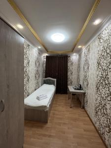 a small room with a bed and a table at Diyora Hostel in Qŭyliq +41 photos