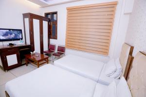 Habitación de hotel con 2 camas y TV en Leela Residency, en Karnal