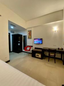 a bedroom with a desk and a tv on a wall at My Inn Hotel Lahad Datu, Sabah in Lahad Datu
