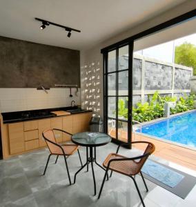 una cocina con mesa y sillas y una piscina en Villa Penny II, en Batu