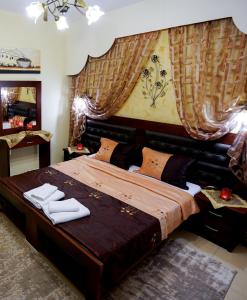 a bedroom with a large bed with a large headboard at Relax pozar in Kato Loutraki