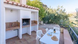 Pinos del Valle的住宿－Encina Gorda El Pinar by Ruralidays，庭院配有桌椅和壁炉。