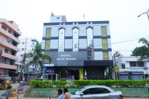 un edificio de luna azul en una concurrida calle de la ciudad en HOTEL BLUE MOON, en Nellore