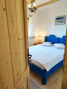 a bedroom with a blue bed in a room at La sat - Blândă Mărie in Bertea