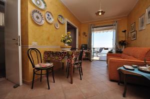 a living room with a table and chairs and a couch at Villa Ridente Maria in Gioiosa Marea