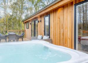a large hot tub in front of a house at Elton Furze Retreats 