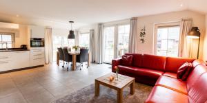 a living room with a red couch and a table at Hof van Salland Hellendoorn in Hellendoorn