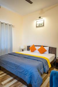 MāvalliにあるCoastal Pearl Home Stay, Murudeshwarのオレンジ色の枕が付いた大きなベッドのある寝室