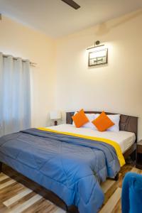 um quarto com uma cama grande e almofadas laranja em Coastal Pearl Home Stay, Murudeshwar em Māvalli