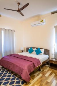 um quarto com uma cama grande e almofadas azuis e brancas em Coastal Pearl Home Stay, Murudeshwar em Māvalli