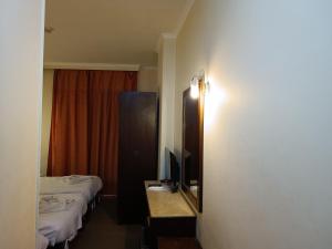 a hotel room with two beds and a television at Susanna Hotel Luxor in Luxor