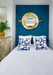 a bedroom with a white bed and a mirror at Apartments WS Opéra - Laffitte in Paris