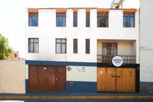 a white and blue building with wooden doors at Lovely 3bedroom apt infront Sta Catalina Monastery in Arequipa