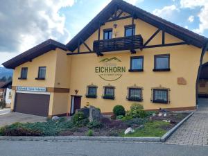 un bâtiment jaune avec un panneau indiquant l'électrnium dans l'établissement Pension Eichhorn, à Bayerisch Eisenstein