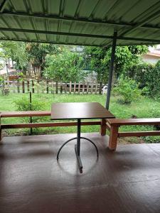 una mesa de picnic bajo una sombrilla en un parque en ชิดชล โฮมสเตย์ แอทอัมพวา, en Bang Khon Thi