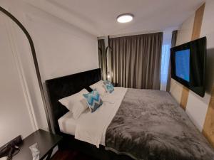 a bedroom with a bed with pillows and a television at Apartman Vučko 118 in Jahorina