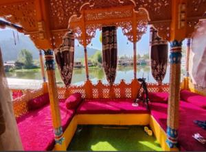 een bed in een boot met uitzicht op een rivier bij Houseboat Moon of Kashmir in Srinagar