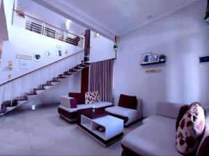 a living room with a couch and a staircase at Papringan Suite House in Demangan
