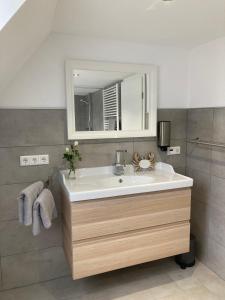 a bathroom with a sink and a mirror at Balance Apartments by M&A - Ferienwohnung Dohrenbach in Witzenhausen