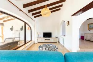 a living room with a blue couch and a tv at Villa ISLANDIA SUPER CÓMODA in Jávea