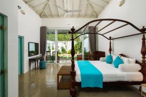 a bedroom with a canopy bed with blue accents at Angam Villas Colombo in Colombo +133 photos