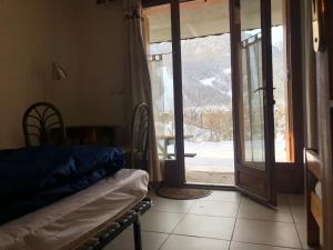 um quarto com uma cama e uma porta de vidro deslizante em Chalets La Caillaude em La Salle Les Alpes