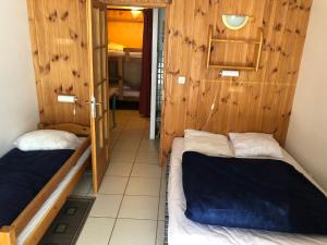 Duas camas num quarto com paredes de madeira em Chalets La Caillaude em La Salle Les Alpes