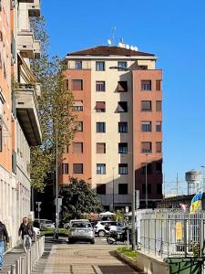 un edificio con coches aparcados en una calle de la ciudad en Enzo, en Milán