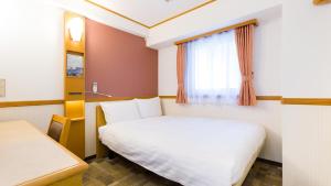 奈良市にある東横INN奈良新大宮駅前のベッドと窓が備わる小さな客室です。