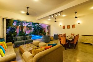 a living room with a table and a dining room at Angam Villas Colombo in Colombo