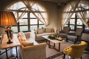 a living room with couches and chairs and windows at Kyniska Palace Conference & Spa in Mystras +77 photos
