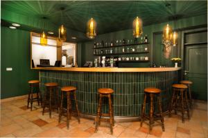 a bar with brown stools at a green wall at Hirschenhof in Spital am Semmering