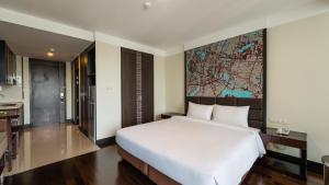 a bedroom with a large white bed and a map on the wall at Jasmine Grande Residence in Bangkok