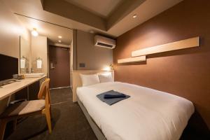 中津川市にあるお宿Ｏｎｎ 中津川の大型ベッドとシンクが備わるホテルルームです。