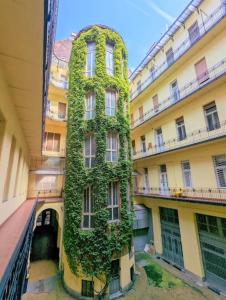 a building with ivy growing on the side of it at Purple Room - Stylish and lively central studio in Budapest