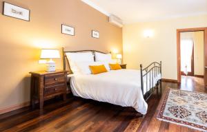 1 dormitorio con 1 cama con sábanas blancas y almohadas amarillas en Buccara B&B Due Del Monte, en Cormòns
