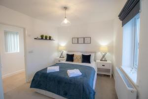 a bedroom with a bed with two towels on it at Crescent House Apartments in Telford
