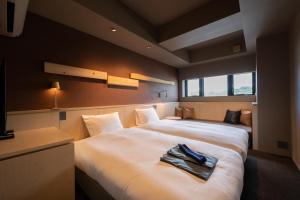 a hotel room with two beds with towels on them at Onn nakatsugawa in Nakatsugawa