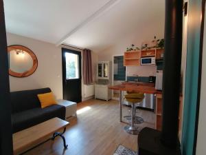 a living room with a couch and a kitchen at Les Callunes chambres d'hôtes et location meublée à 800 m de la plage ! in Lanton