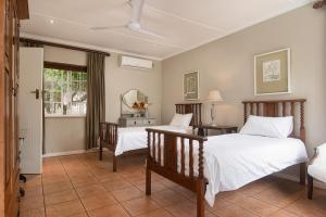 a bedroom with two beds and a table and a mirror at Isoyi On The Mill in Durban