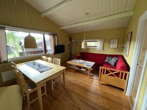 ein Wohnzimmer mit einem roten Sofa und einem Tisch in der Unterkunft Lullens Stugby - Stugorna 1-5 in Bruksvallarna