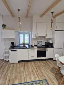 una cocina con electrodomésticos blancos, mesa y sillas en casa CARREGAL, en Tomiño