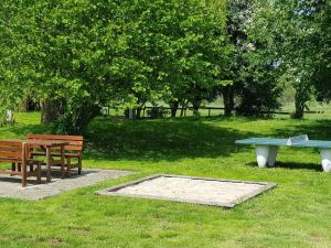 a picnic table and two benches in a park at Ferien-Residenz am Nationalpark Wohnung 6 in Gingst