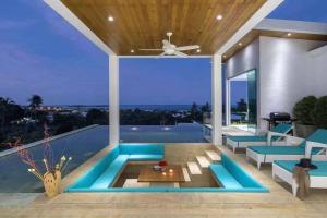 a house with a swimming pool with blue furniture at Silver Beach 3br Sea View Pool&Wine Private Villa in Koh Samui 